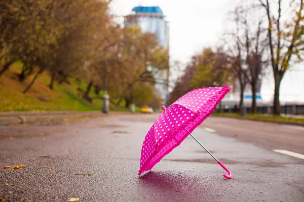 Çocuk şemsiye açık havada ıslak asfalt üzerinde pembe — Stok fotoğraf