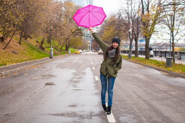 Young woman walking with umbrella in autumn rainy day — Stock Photo, Image