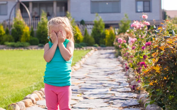 Liten flicka som täcker hennes ansikte, inte vill bli fotograferad — Stockfoto