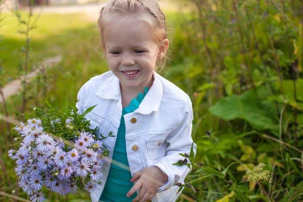 Kleines nettes Mädchen, das mit einem Blumenstrauß geht — Stockfoto