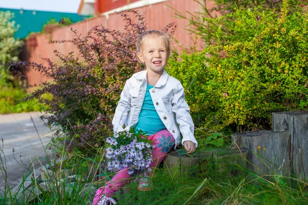 Pequena menina bonito andando com um buquê de flores — Fotografia de Stock