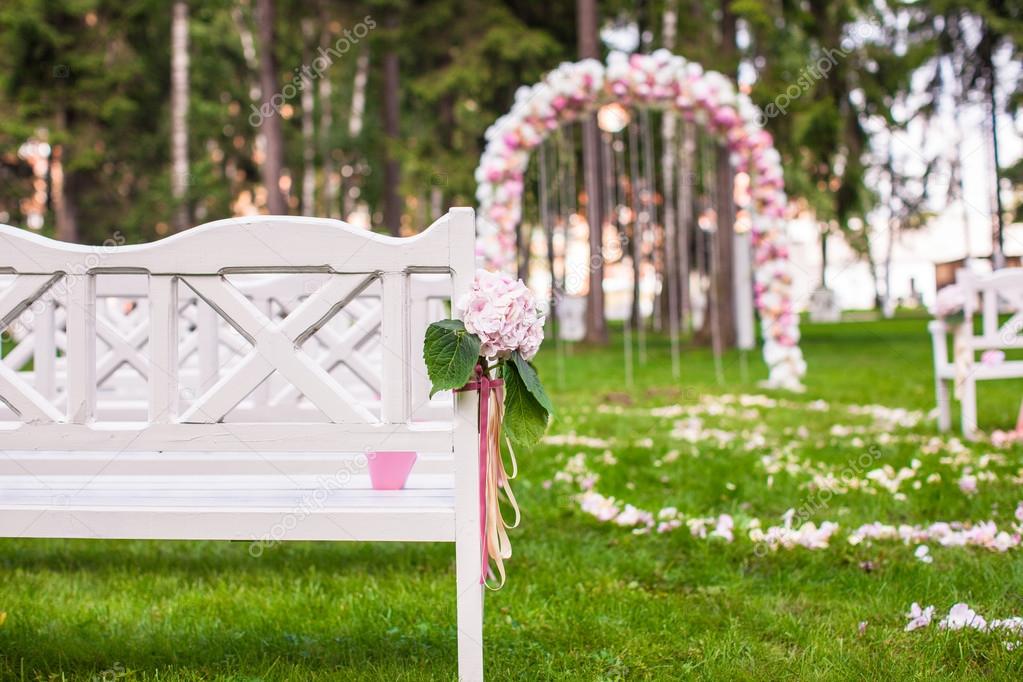 Wedding benches and flower arch for ceremony outdoors