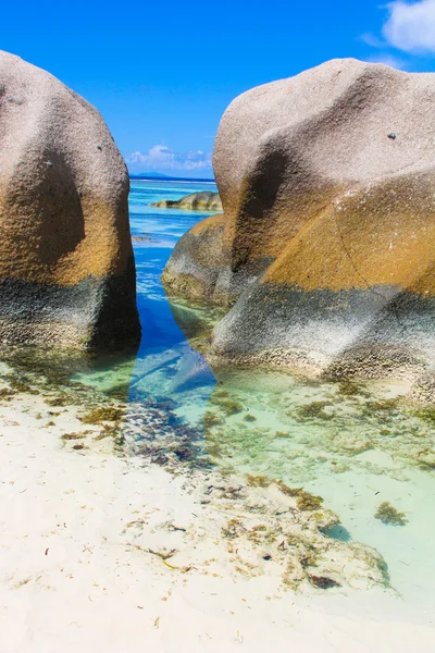 Exotic turquoise lagoon between large smooth rocks in the Seychelles — Stock Photo, Image
