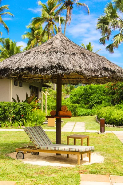 Tumbonas bajo un paraguas en la piscina del hotel en Seychelles —  Fotos de Stock