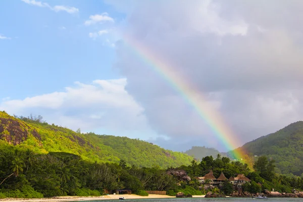 Rainbow over trooppinen saari ja ylellinen hotelli Seyshelles — kuvapankkivalokuva