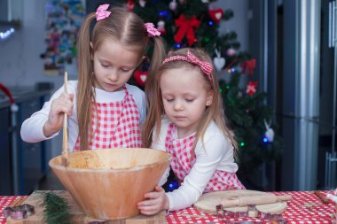 küçük şirin kız gingerbread çerezleri Noel için pişirin.