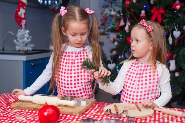 Zwei kleine entzückende Mädchen bereiten Lebkuchen für Weihnachten vor — Stockfoto