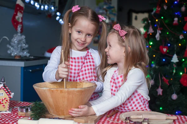 Lilla söta systrar bakar pepparkakor till jul — Stockfoto