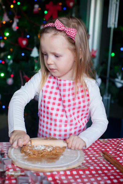 Adorable little girl with rolling pin baking gingerbread cookies for Christmas — Stock Photo, Image