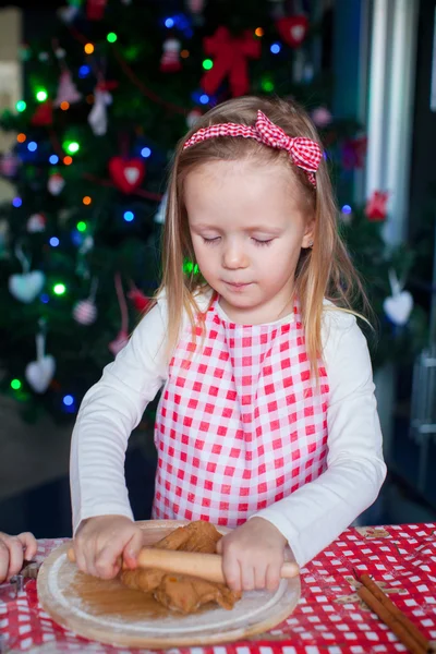Niña feliz con rodillo horneando galletas de jengibre para Navidad — Foto de Stock