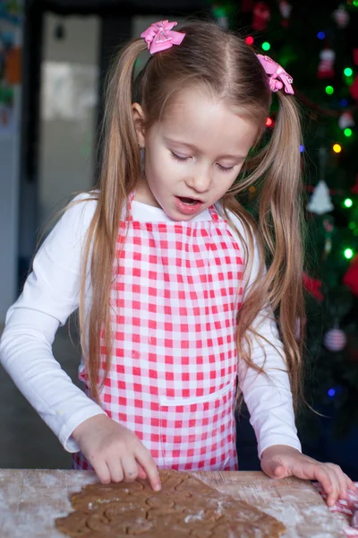 Menina fazendo biscoitos de gengibre para o Natal em casa — Fotografia de Stock