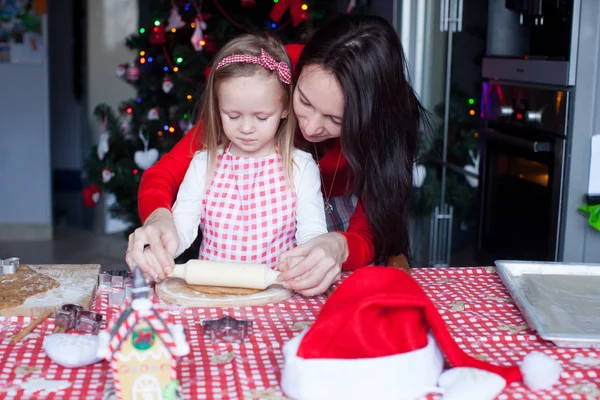 一緒にクリスマスのジンジャーブレッドのクッキーを焼く美しい母親と小さな女の子 — ストック写真
