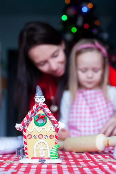 幸せな家族の背景にカラフルなキャンディーで飾られたジンジャーブレッドの妖精の家 — ストック写真