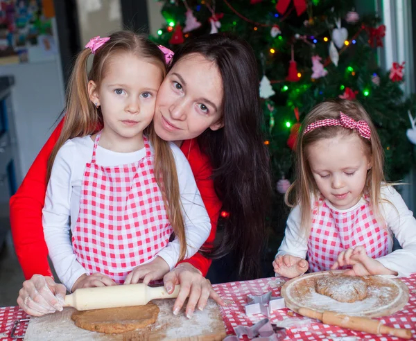 Niñas adorables y madre joven hornear galletas de jengibre de Navidad —  Fotos de Stock