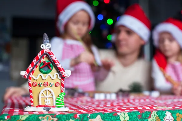 Lebkuchenmärchenhaus mit bunten Bonbons auf dem Hintergrund einer glücklichen Familie dekoriert — Stockfoto