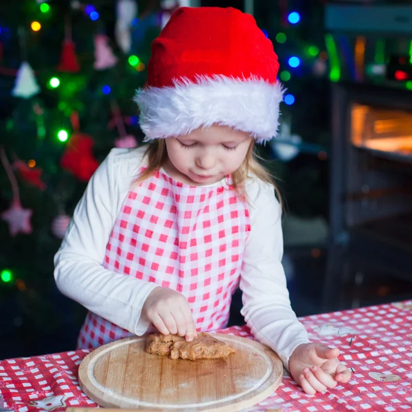 Αξιολάτρευτο κοριτσάκι που τρώει τη ζύμη για τα μπισκότα πιπεροριζών στην κουζίνα — Φωτογραφία Αρχείου