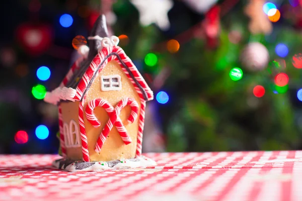 Maison de fée en pain d'épice décorée de bonbons colorés sur un fond d'arbre de Noël lumineux avec guirlande — Photo