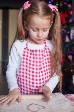 Noel için gingerbread çerezleri fırın oklava ile küçük mutlu kız