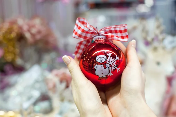 Bola vermelha bonita em mãos de mulher jovem de Natal — Fotografia de Stock
