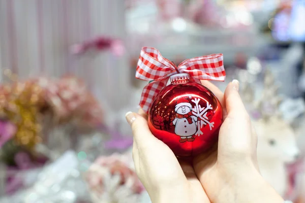 Красивый красный шар в руках молодой женщины на Рождество — стоковое фото