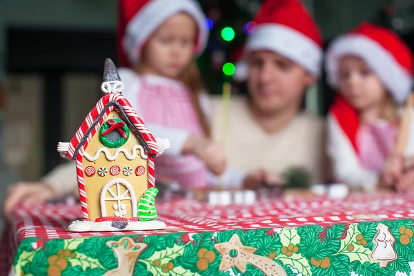 幸せな家族の背景にカラフルなキャンディーで飾られたジンジャーブレッドの妖精の家 — ストック写真