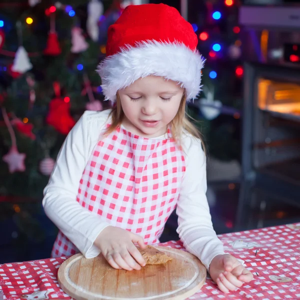 Bedårande liten flicka med brödkavel baka pepparkakor till jul — Stockfoto