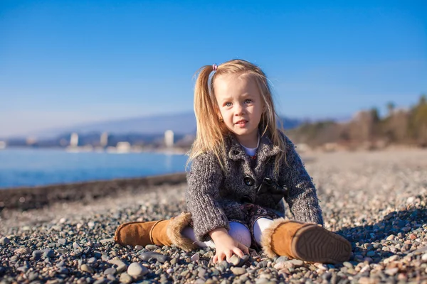 Adorable petite fille sur la plage dans un pull confortable et robe à la chaude journée d'hiver — Photo