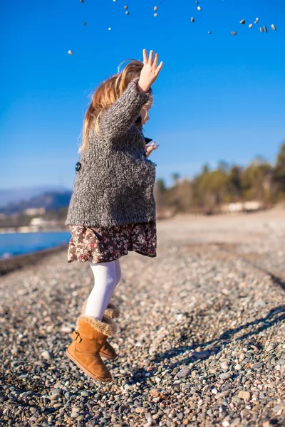 Entzückendes kleines Mädchen am Strand, das an einem warmen Wintertag Spaß hat — Stockfoto