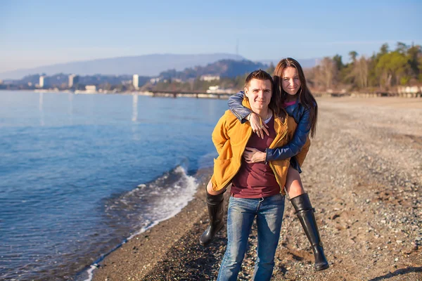 Glückliches Paar, das an einem sonnigen Wintertag Spaß am Strand hat — Stockfoto