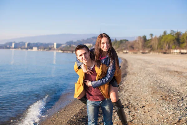 Glückliches Paar, das an einem sonnigen Wintertag Spaß am Strand hat — Stockfoto