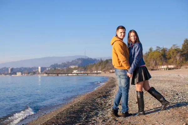 Jong koppel wandelen op het strand op een zonnige winterdag — Stockfoto