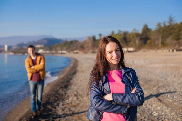 Closeup of happy woman on a background the young man at winter beach — Stock Photo, Image