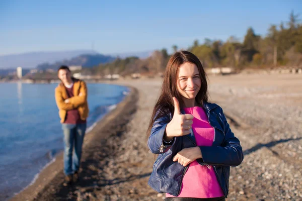 Pareja joven juntos en una playa vacía en invierno día soleado — Foto de Stock