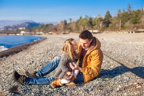 晴れた日のビーチでキスは小さな娘を保持している若い父親 — ストック写真