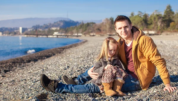 Młody ojciec i dziewczynki na plaży w dzień słoneczny zimowy — Zdjęcie stockowe