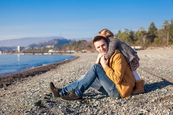 Entzückendes Mädchen umarmt seinen jungen Vater am Strand — Stockfoto