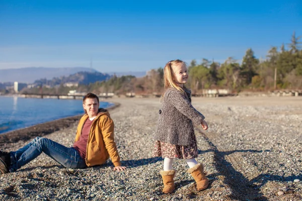 Adorable little girl with father having fun on beach in winter warm day — Stock Photo, Image