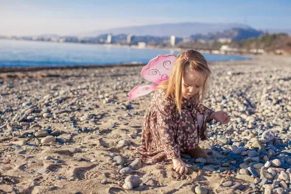 Adorable petite fille qui s'amuse sur la plage par une journée ensoleillée d'hiver — Photo
