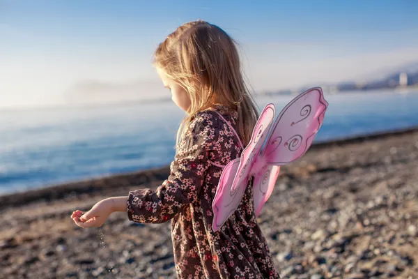 可爱的小女孩，在一个阳光明媚的冬日，在海滩上玩乐 — 图库照片