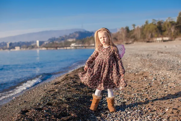 Adorable petite fille sur la plage par une journée ensoleillée d'hiver — Photo