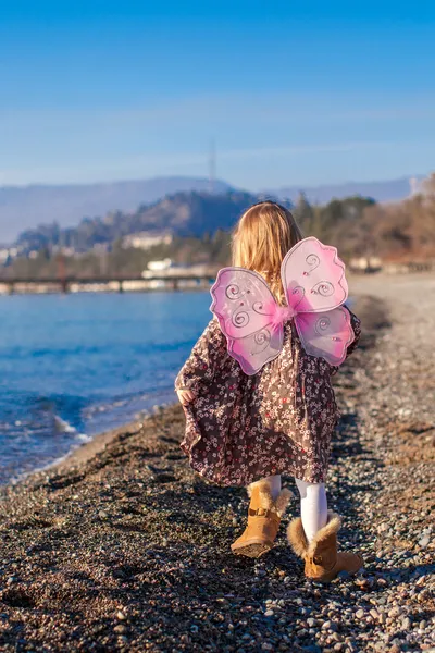 Adorable petite fille sur la plage par une journée ensoleillée d'hiver — Photo