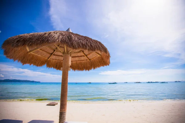 Straw umbrella on a tropical beach — Stock Photo, Image