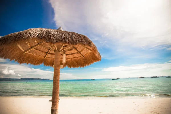 Straw umbrella on a tropical beach — Stock Photo, Image