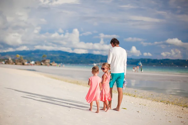 Back view of father and his two little daughters walking by the sea — Stock Photo, Image