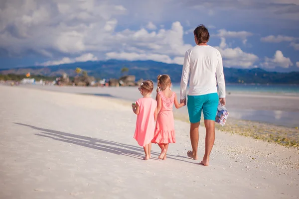 Adorable little girls and young father on tropical white beach — Stock Photo, Image