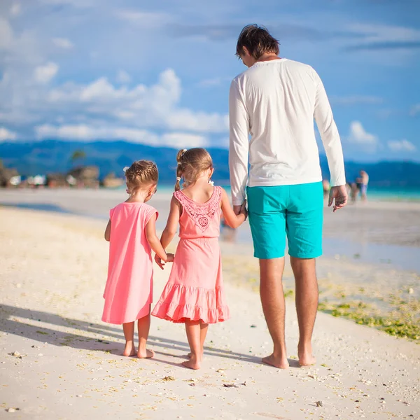 Back view of father and two girls walking on tropical white beach — Stock Photo, Image