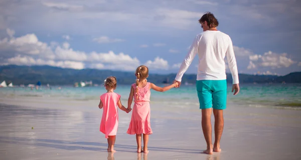 Adorable little girls and young father on tropical white beach — Stock Photo, Image