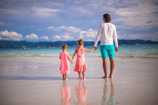 Adorable little girls and young father on tropical white beach — Stock Photo, Image