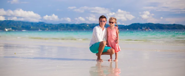 Adorable girl and young man on white sandy beach — Stock Photo, Image