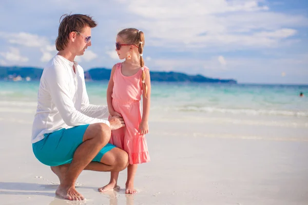 Adorable girl and young man on white sandy beach — Stock Photo, Image